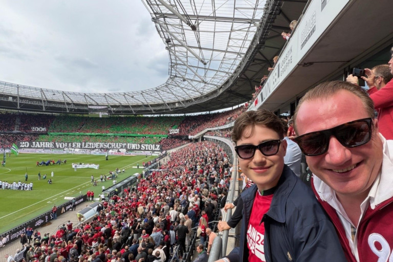 Fußballspiel im Stadion mit begeisterten Zuschauern auf der Tribüne Fußballstadion mit jubelnden Fans bei einem Sportereignis, Blick von der Tribüne