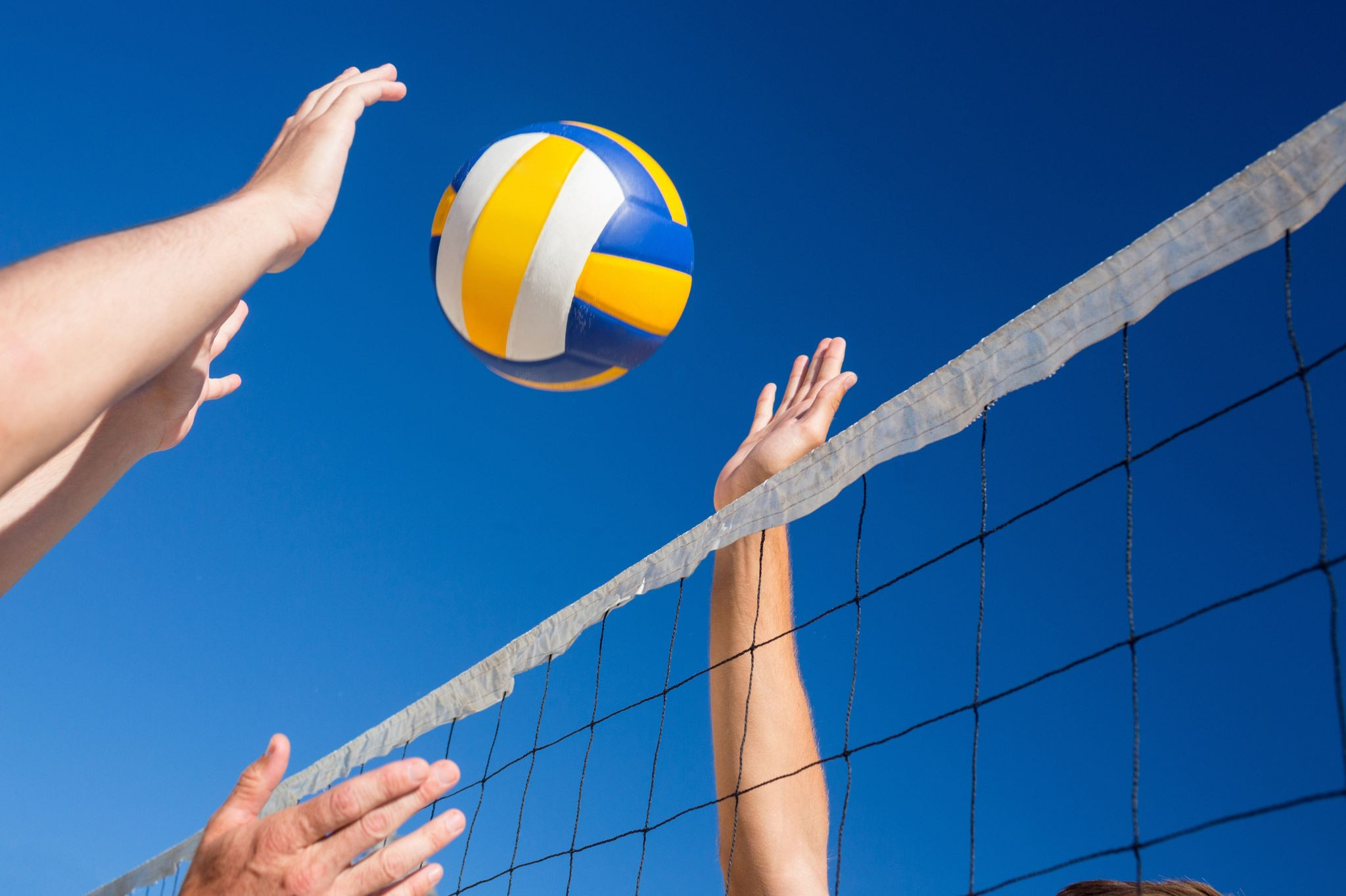 Sport Aufmacher: Volleyball-Spiel am Netz unter blauem Himmel