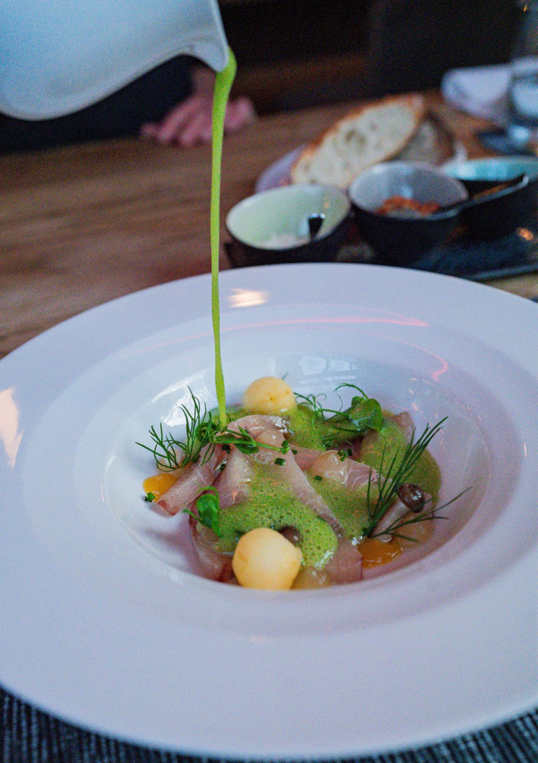 Gourmetgericht im Restaurant Hindenburg – moderne Küche mit frischen Zutaten Feines Gericht im Restaurant Hindenburg, angerichtet mit frischen Kräutern und grüner Soße
