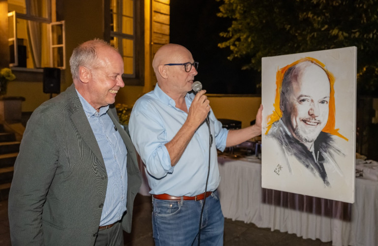 Kinderherz Hannover e.V. 21 Jahre Charity Gala – Zwei Männer mit Porträtbild auf der Veranstaltung Zwei Männer bei der 21 Jahre Charity Gala von Kinderherz Hannover e.V., einer hält ein Mikrofon und ein Porträtbild.