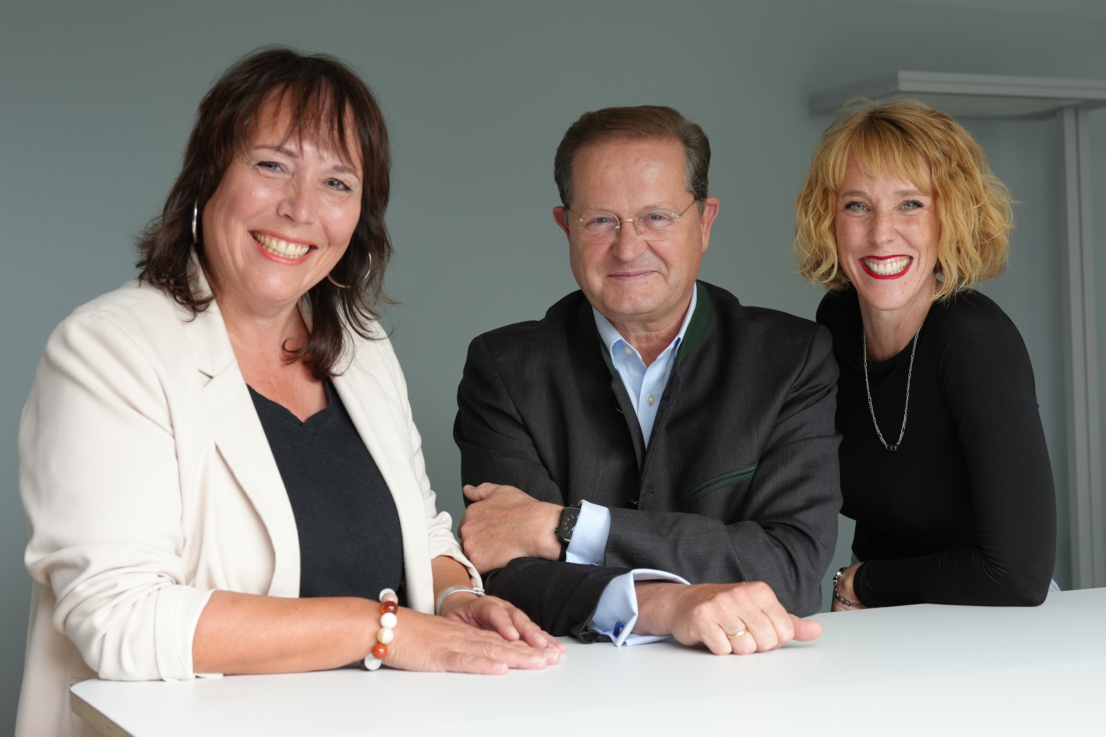 Das Team von Civilia gemeinsam an einem Stehtisch. Sie lächeln in die Kamera.