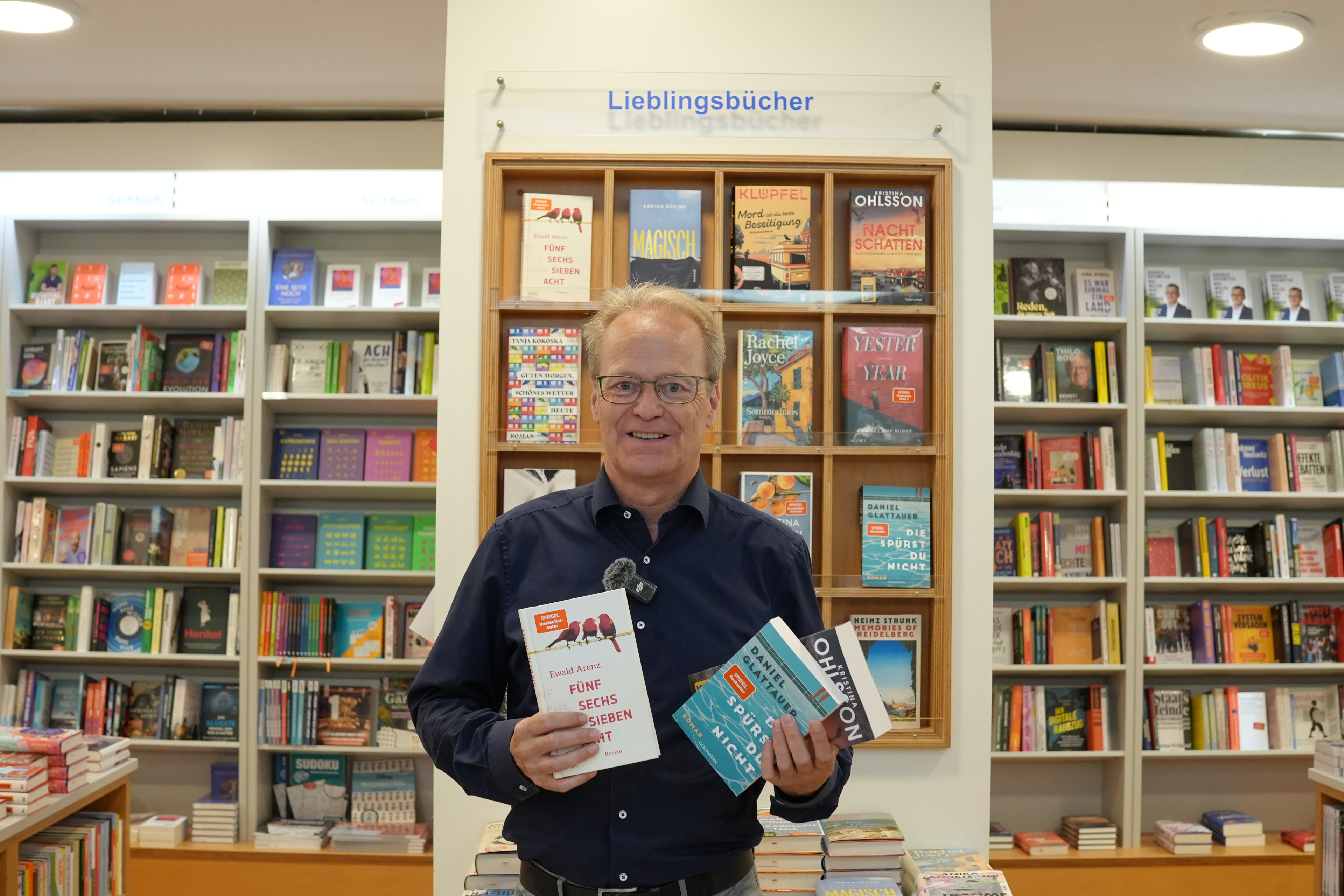 Dirk Eberitzsch steht vor einem Regal mit der Aufschrift 