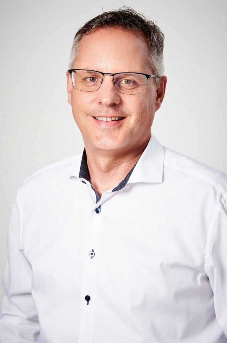 993 aufmacher 1 – Porträtfoto eines Mannes mit Brille und weißem Hemd 993 aufmacher 1 – Porträt eines lächelnden Mannes mit Brille und weißem Hemd