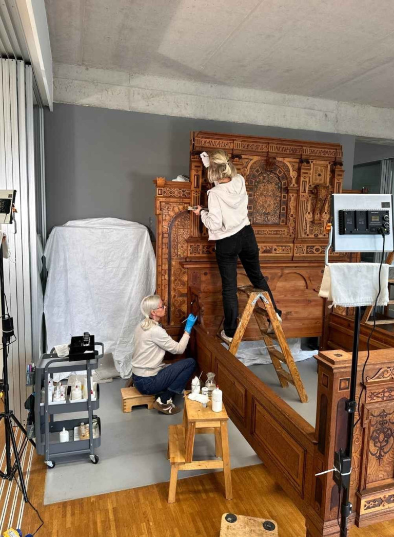 Barbara Helmrich bei der Restaurierung eines historischen Holzbettes