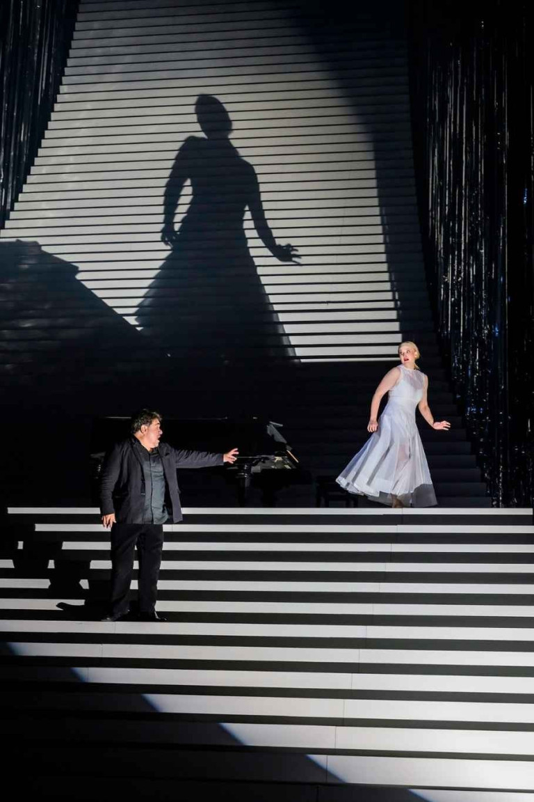 Finalszene der Oper Pique Dame – dramatische Inszenierung auf der Bühne Szenenbild aus der Oper Pique Dame im Finale mit dramatischer Bühnenbeleuchtung und zwei Darstellern auf einer Treppe