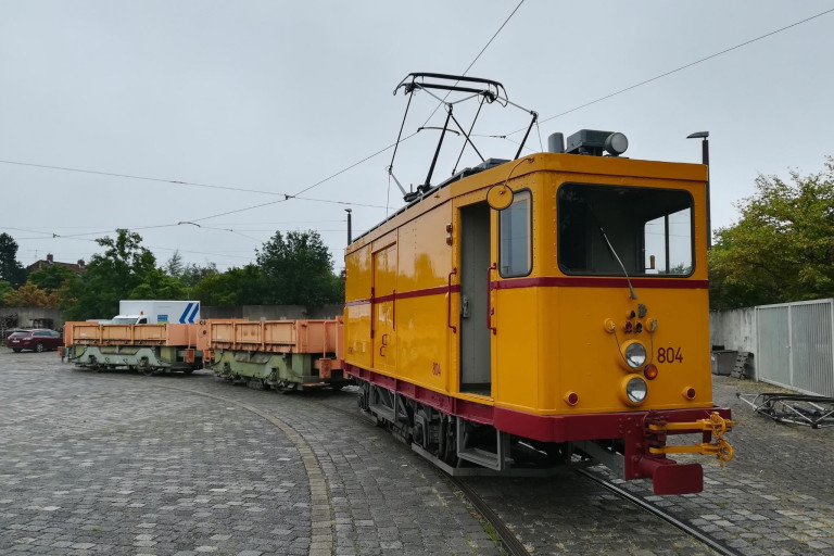 Gelbe Arbeitsstraßenbahn auf Gleisen – Trams-2 Gelbe Straßenbahn mit Arbeitswagen auf Gleisen, Seitenansicht