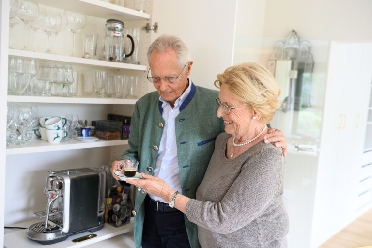Älteres Paar genießt gemeinsam eine Tasse Kaffee in der Küche – Symbol für lange Liebe