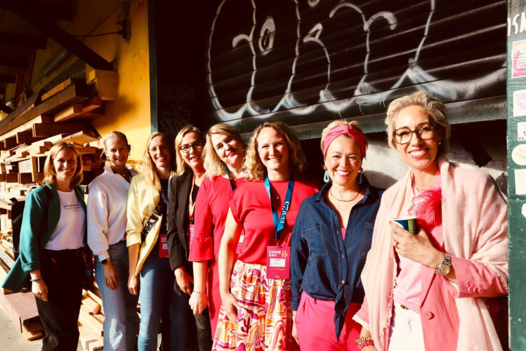 Gruppenfoto von Frauen bei einem Event in Frankfurt, aufgenommen vor einer Wand mit Graffiti.