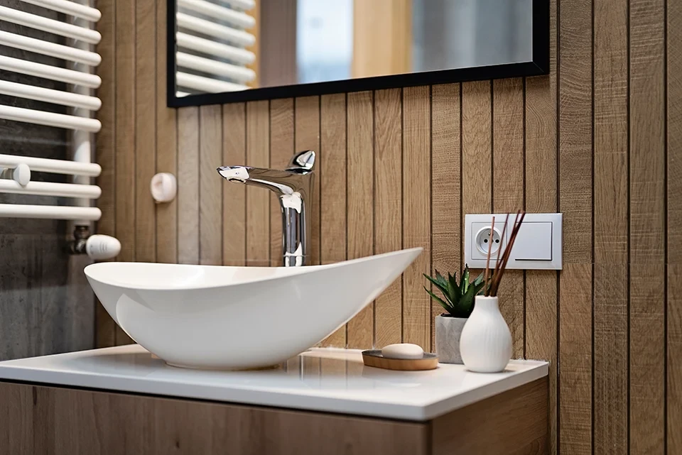 Moderne Badeinrichtung mit Waschbecken, Holzverkleidung und Dekoration