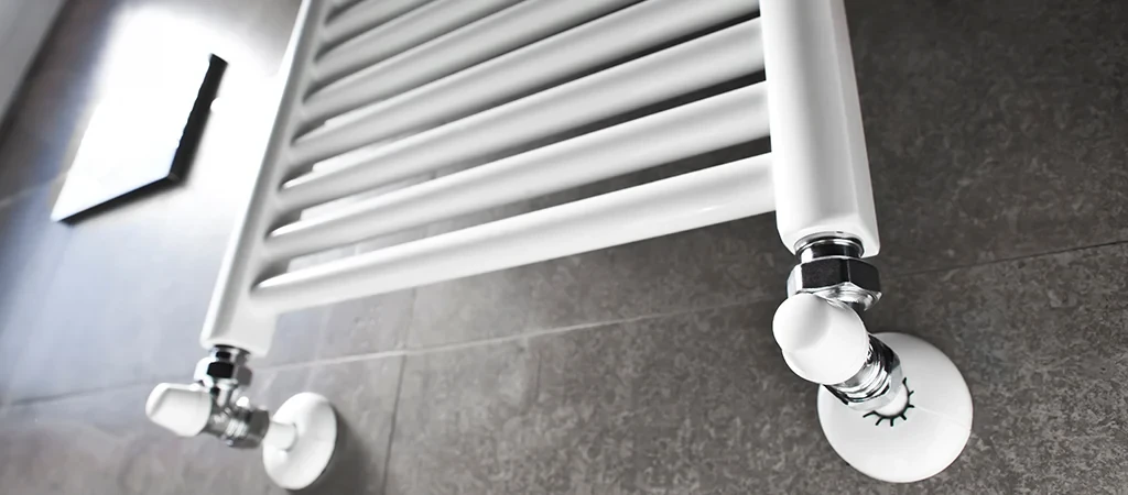 Moderner weißer Badheizkörper auf grauen Fliesen – Detailansicht