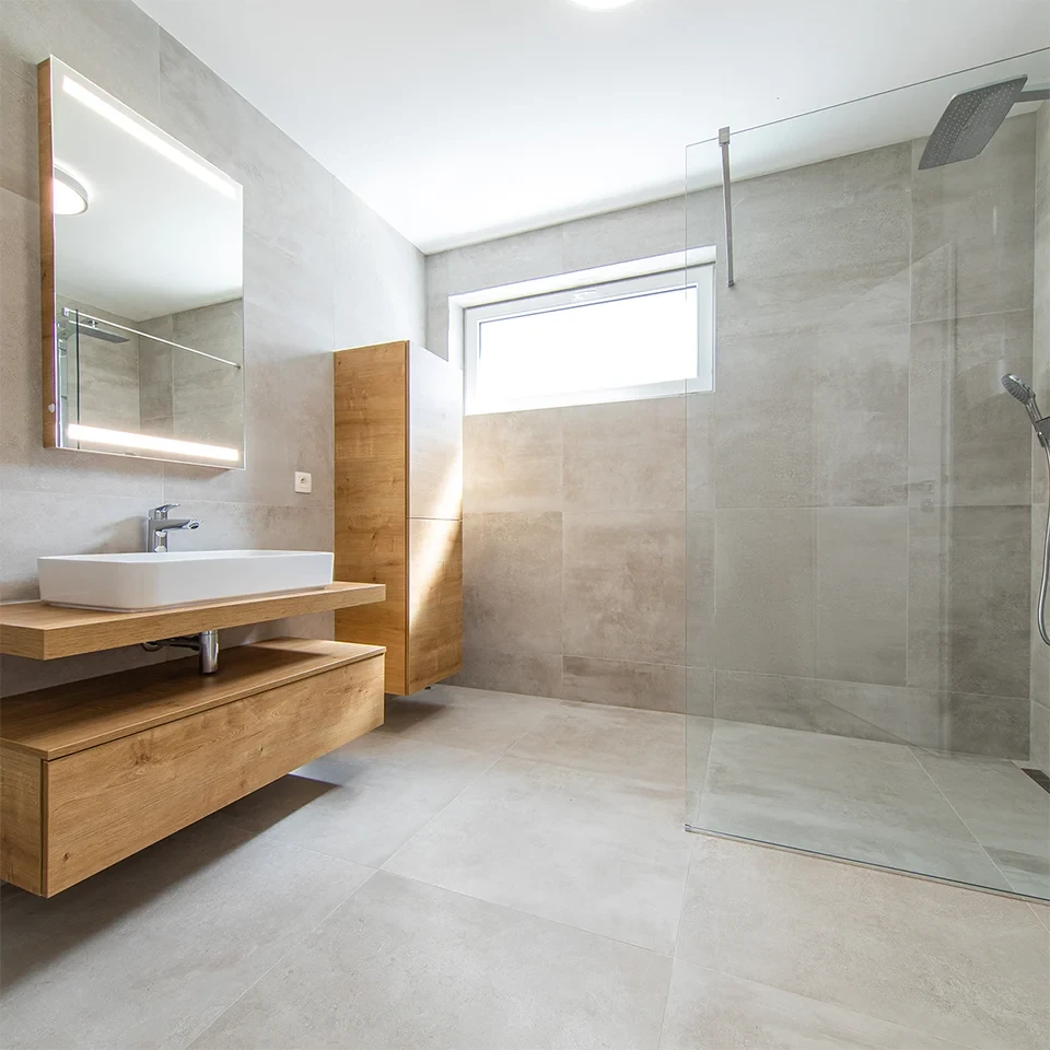 Modernes ebenerdiges Bad mit bodengleicher Dusche, Holzwaschtisch und großformatigen Fliesen