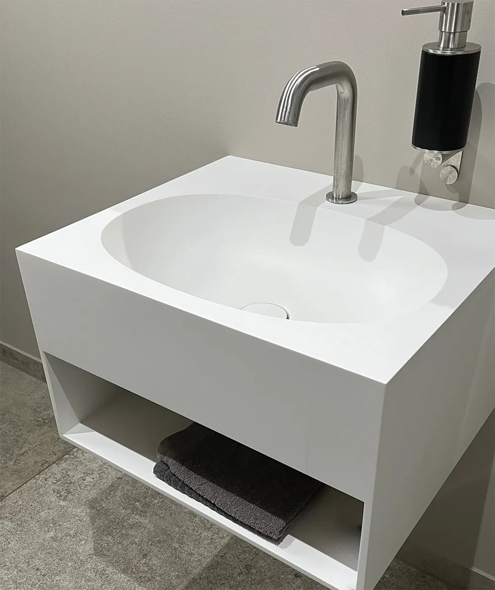 Moderne Badeinrichtung aus Keramik mit weißem Waschbecken und Handtuchablage