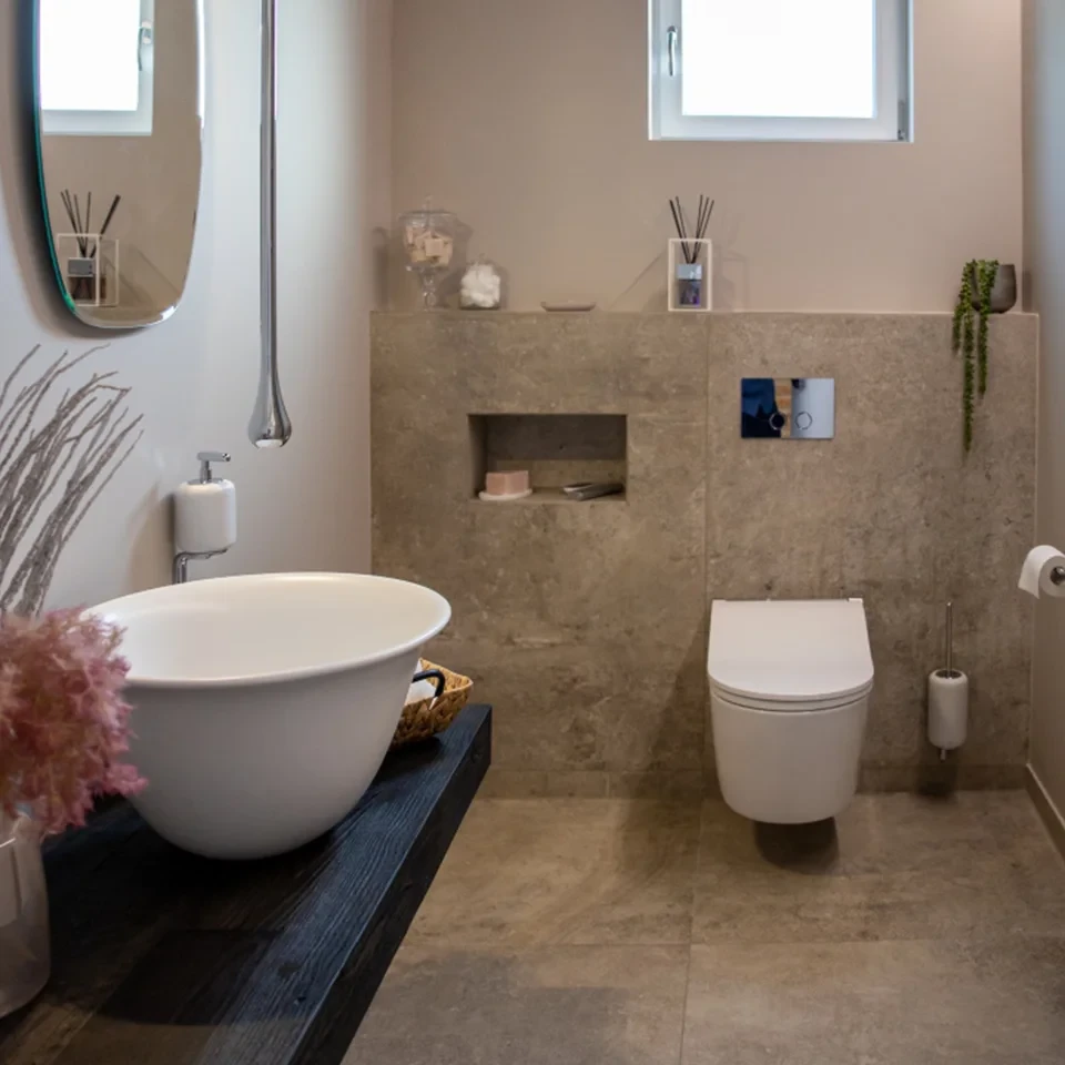 Modernes Gäste-WC nach Sanierung mit stilvollem Waschbecken und Wand-WC