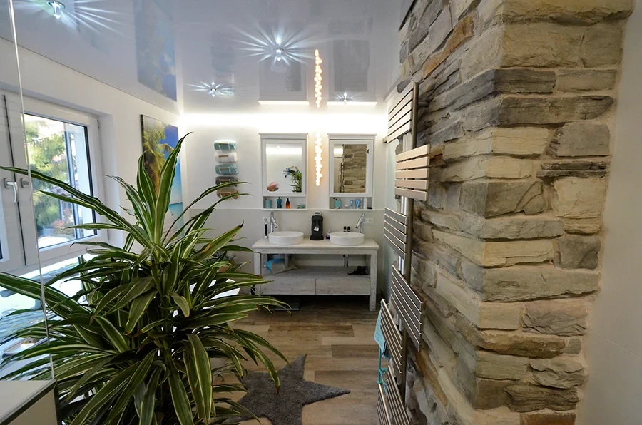 Modernes Badezimmer in Bad Ketsch mit Natursteinwand, Doppelwaschbecken und stilvoller Dekoration