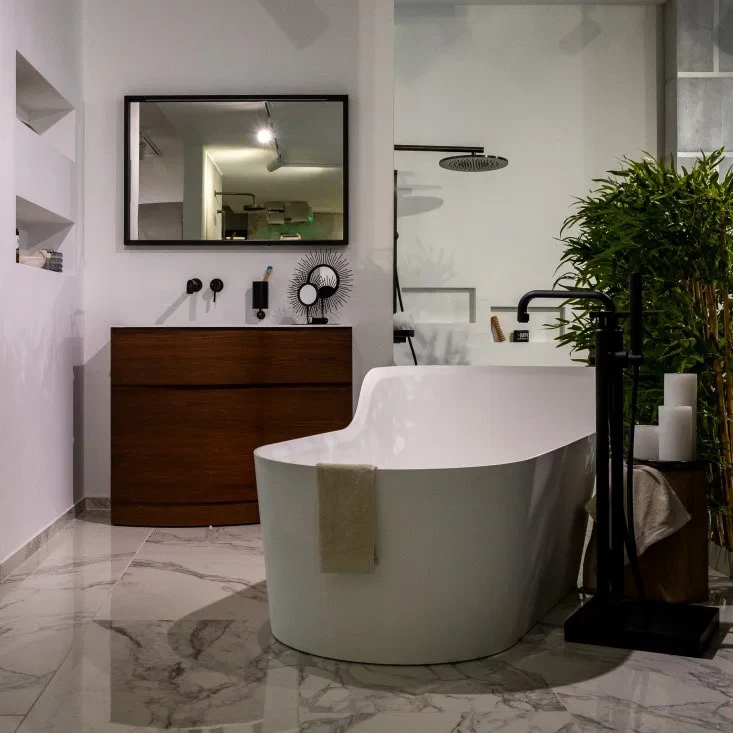 Modernes Badezimmer im Showroom mit freistehender Badewanne, Holzwaschtisch und stilvoller Dekoration