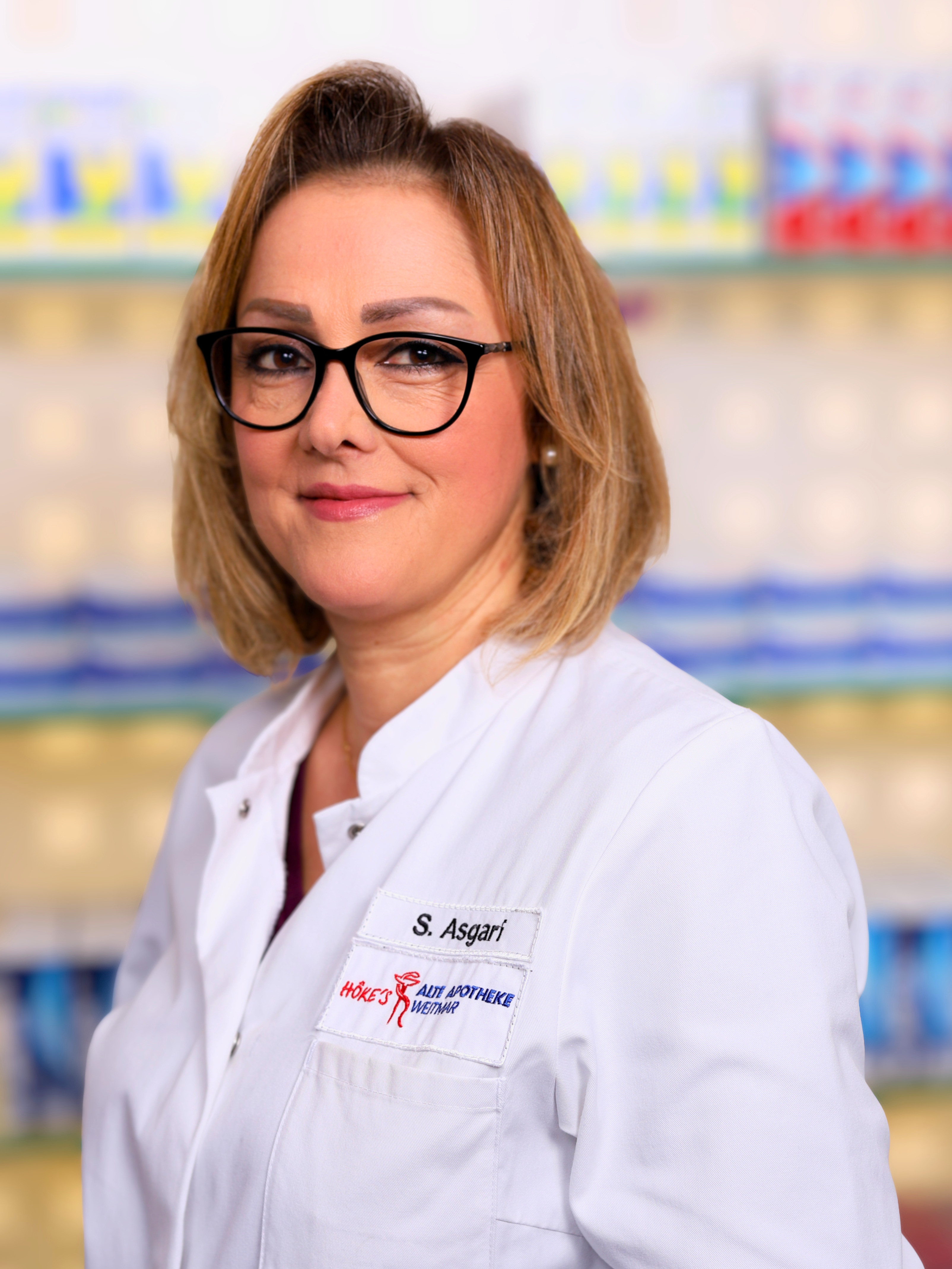S. Asgari in weißem Kittel in der Apotheke