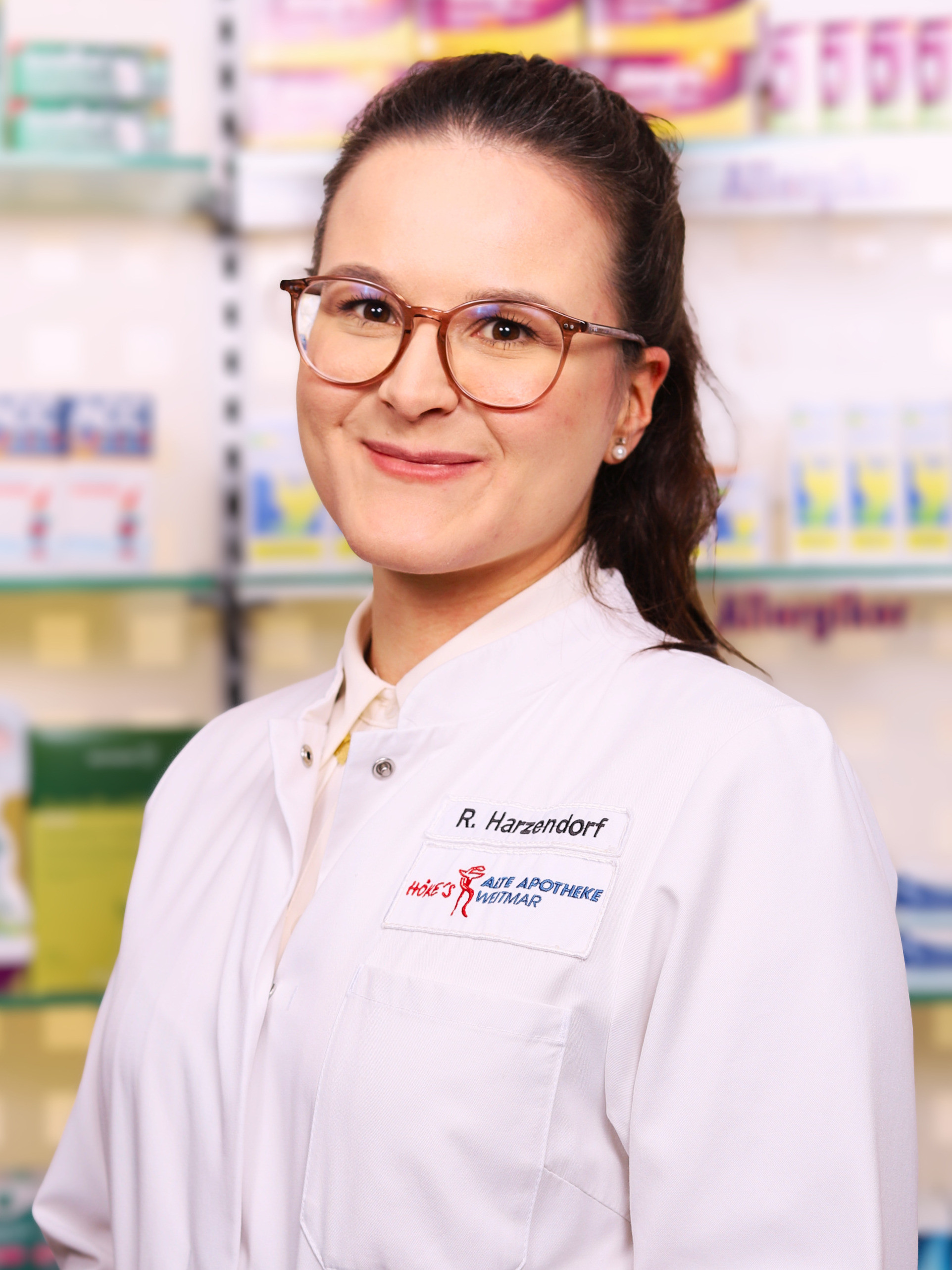 R. Harzendorf von der Alten Apotheke Weitmar in weißem Kittel vor Apothekenregal
