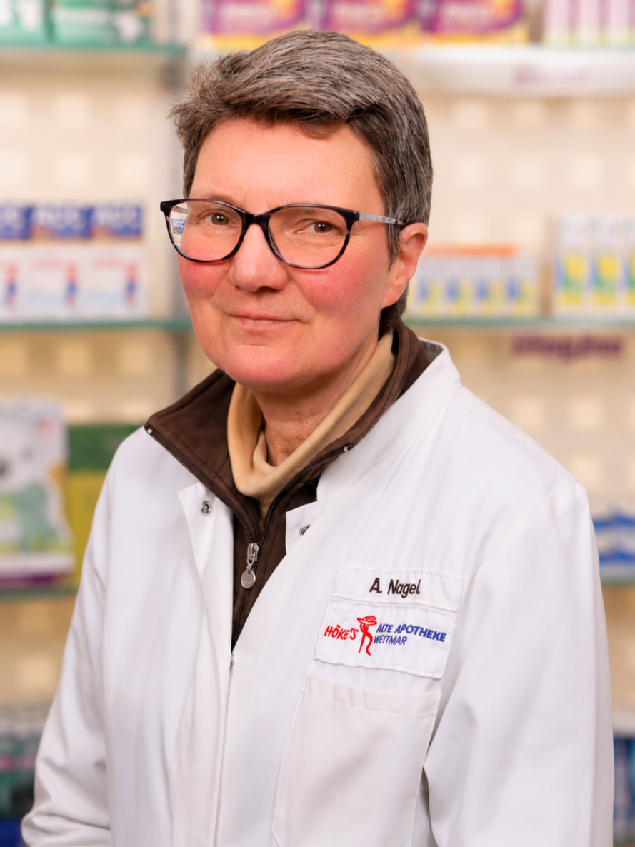Apotheker A. Nagel in weißem Kittel in einer Apotheke