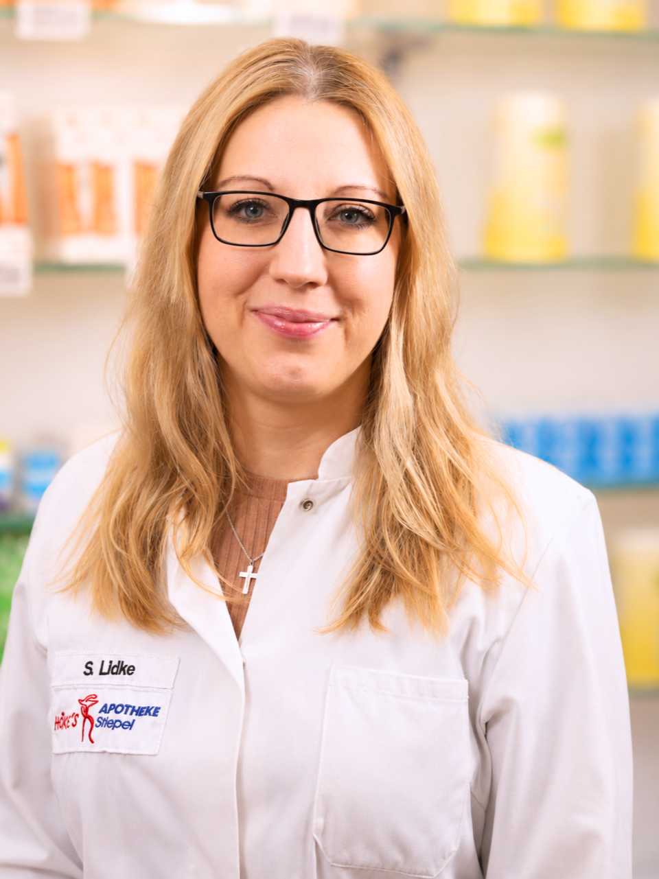 Porträt von S. Lidke in der Apotheke, Mitarbeiterin mit Brille und weißem Kittel