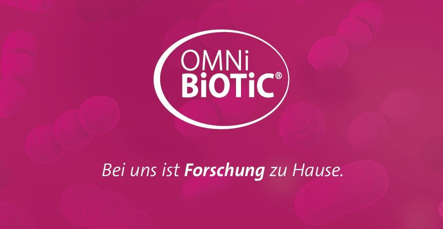 OMNi-BiOTiC Logo mit Slogan 'Bei uns ist Forschung zu Hause' auf pinkem Hintergrund