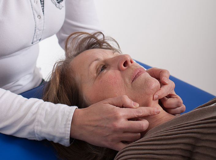 Physiotherapeutische Halsbehandlung einer Frau Frau erhält Halsmassage von Therapeutin