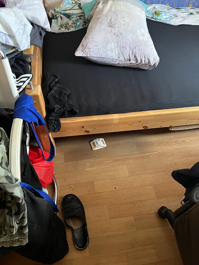 Köderfalle auf dem Boden eines unordentlichen Zimmers neben einem Bett
