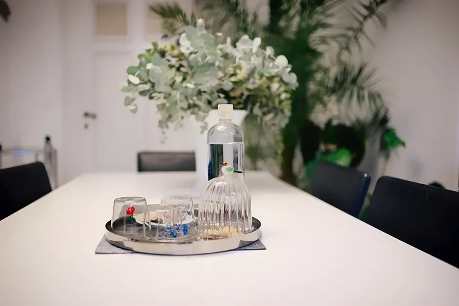 Meetingraum von Jeanette Bazan Schmidt mit gedecktem Tisch, Wasserglas und moderner Dekoration