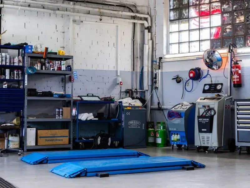 Innenansicht einer modernen Autowerkstatt mit Hebebühne und Werkstattgeräten