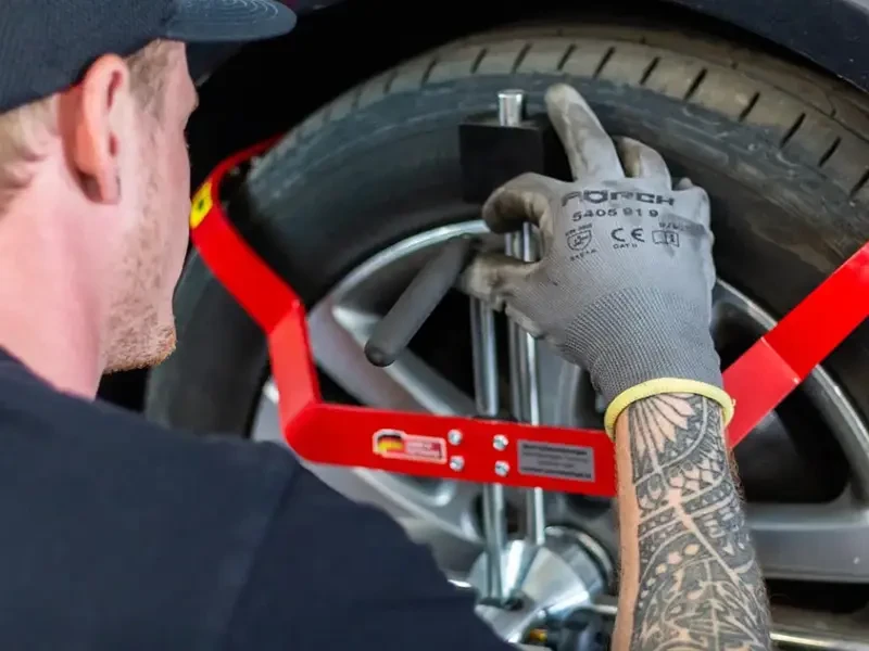 Mechaniker bei der Arbeit am Autoreifen mit Spezialwerkzeug
