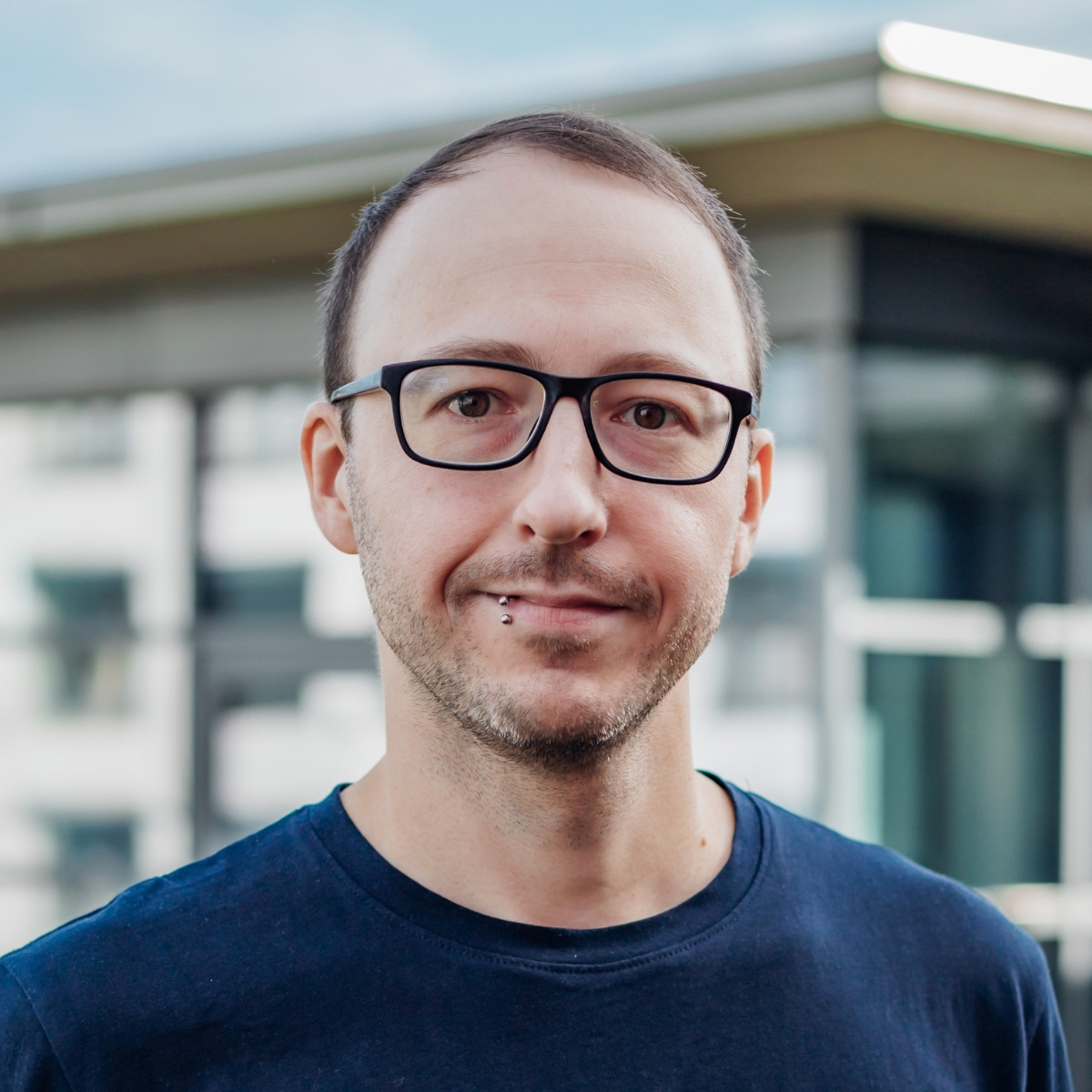 Tobias Ernst im Porträt vor einem modernen Gebäude