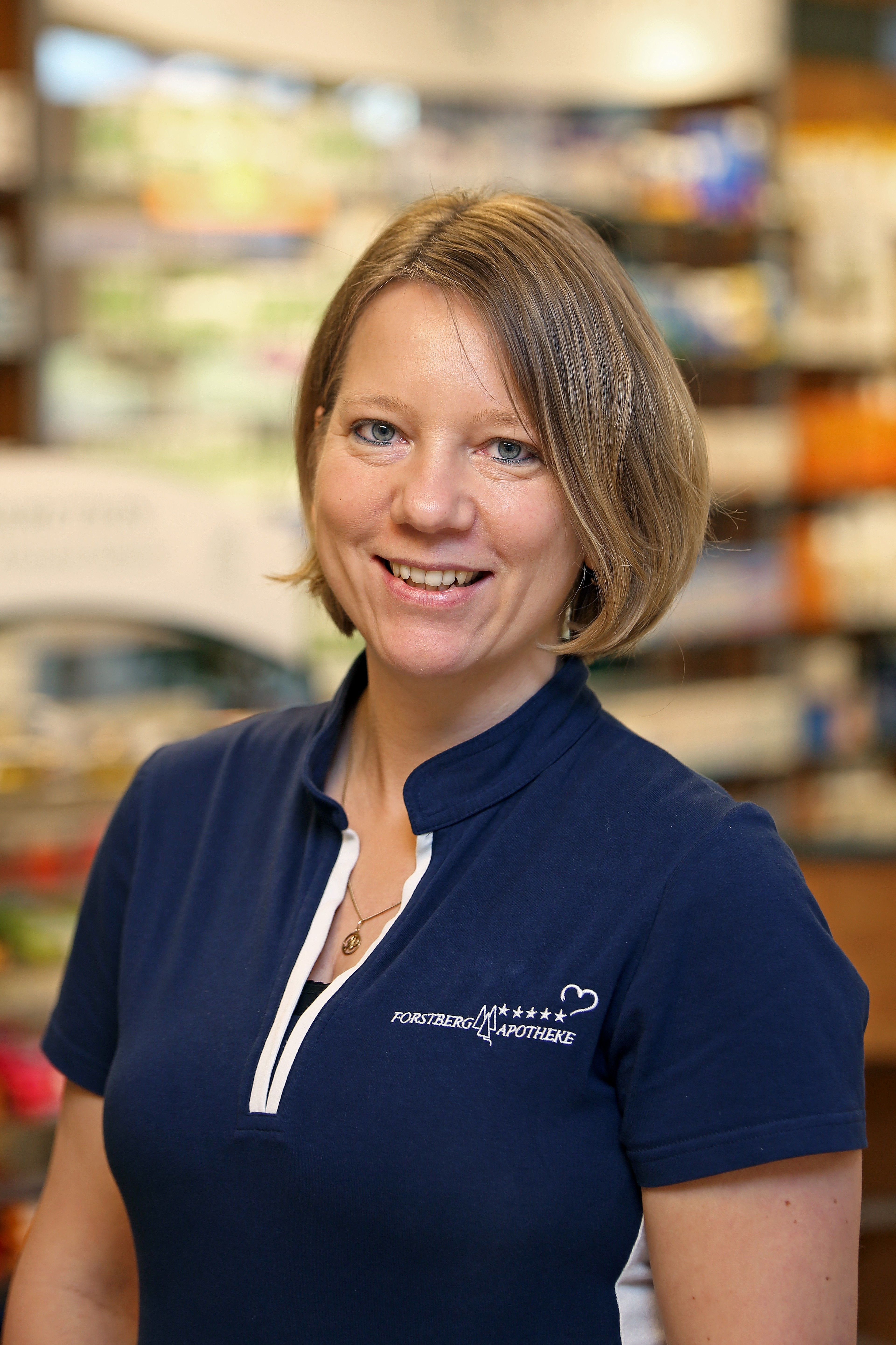 Freundliche Apothekerin in Uniform in der Apotheke