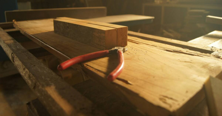 Holzbearbeitung auf einer Werkbank in der Werkstatt Werkbank mit Holz und Zange in einer Werkstatt