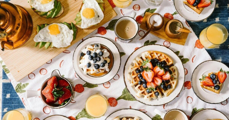 Wie viel Platz brauchst du auf dem Tisch? Frühstücksideen mit Waffeln und Toasts Frühstückstisch mit Waffeln, Toasts mit Avocado und Spiegelei, Kaffee und Saft