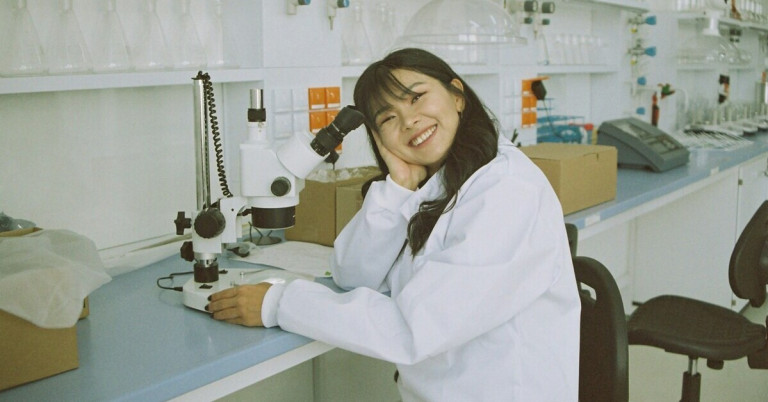 Frau im Labor an Mikroskop bei wissenschaftlicher Arbeit Frau im Labor arbeitet am Mikroskop