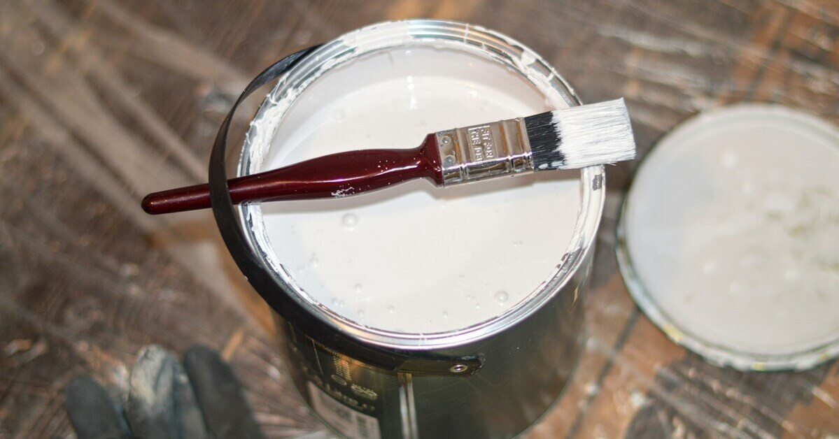 Farbeimer mit weißer Farbe und Pinsel – perfekt zum Streichen und Renovieren Weißer Farbeimer mit Pinsel – frische weiße Farbe zum Streichen