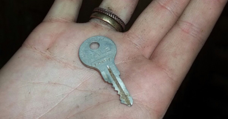 Schlüssel in der Hand – Nahaufnahme eines Schlüssels auf einer Hand Schlüssel in der Hand gehalten, Nahaufnahme einer Hand mit einem Schlüssel