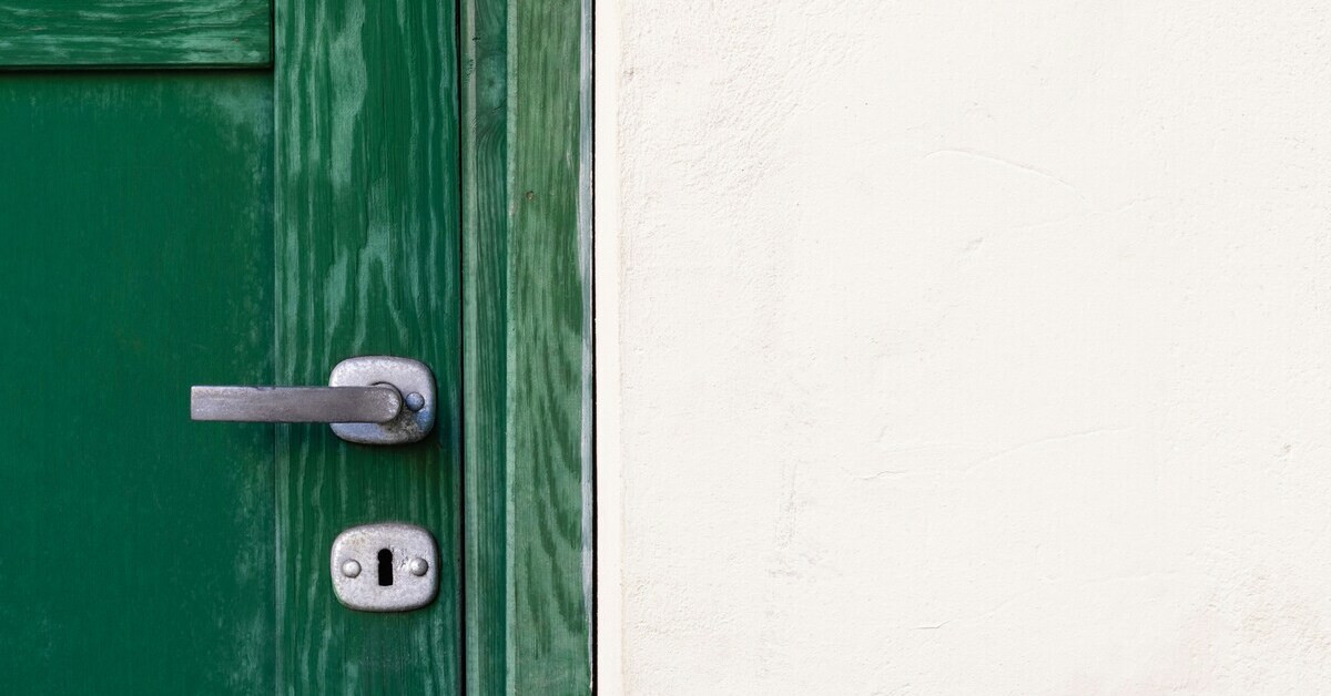 Grüne Tür mit Klinke und Schloss – Detailansicht Grüne Tür mit Klinke und Schloss aus Metall