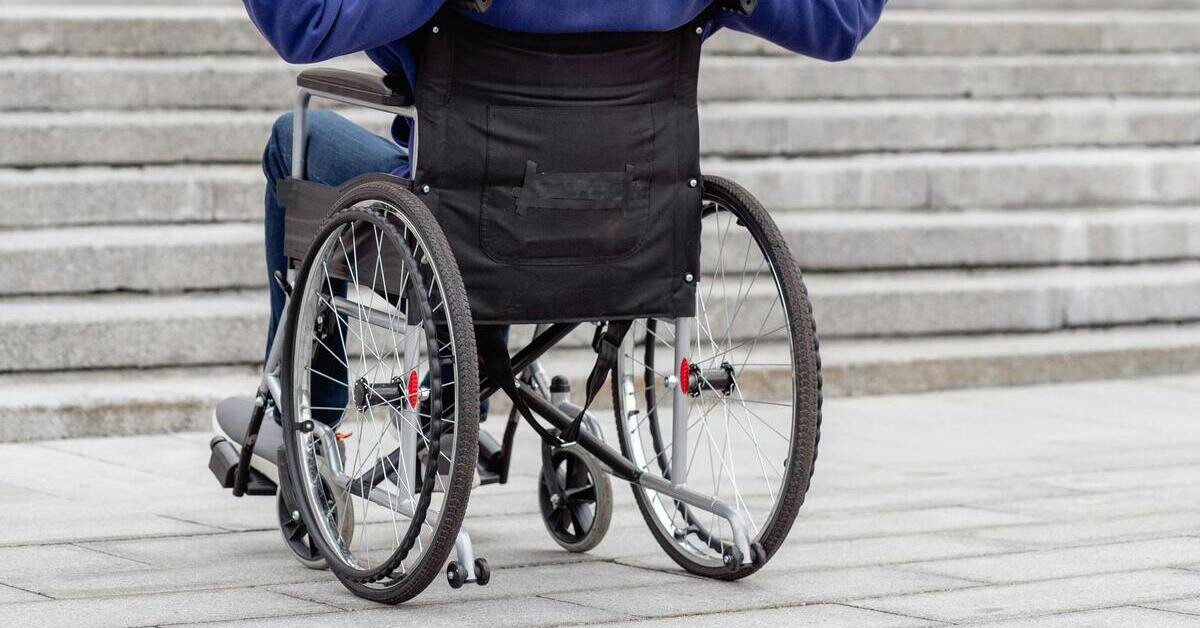 Rollstuhl und Treppen – Beispiel für nicht barrierefreie Zugänge Rollstuhlfahrer vor nicht barrierefreien Treppen – fehlende Barrierefreiheit im öffentlichen Raum