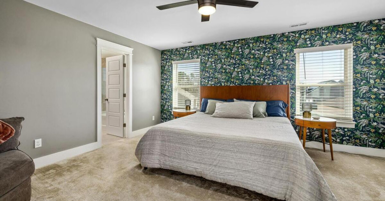 Akzentwand mit gemusterter Tapete im modernen Schlafzimmer Schlafzimmer mit Akzentwand und gemusterter Tapete hinter dem Bett