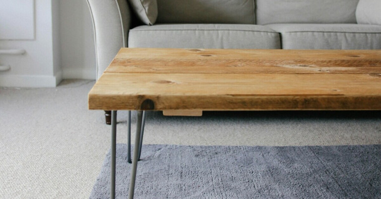 Couchtisch aus Massivholz – moderner Wohnzimmertisch mit Metallbeinen Moderner Couchtisch aus Massivholz mit Metallbeinen vor einem grauen Sofa