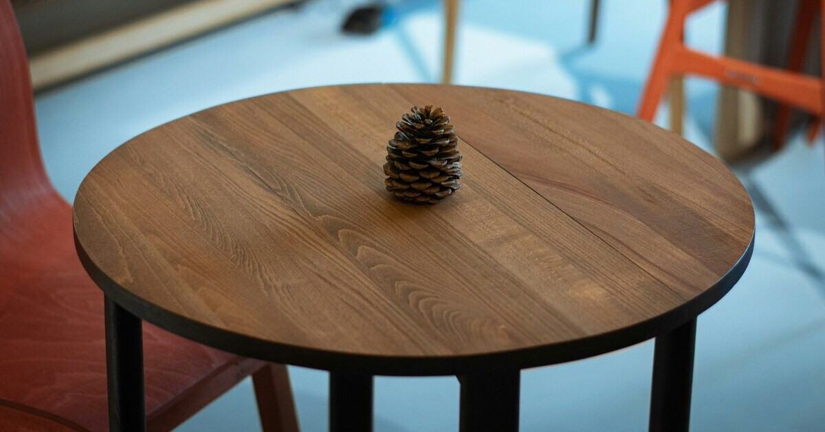 Gepflegter Beistelltisch aus Holz – stilvolle Dekoration mit Tannenzapfen Gepflegter Beistelltisch aus Holz mit Tannenzapfen als Dekoration