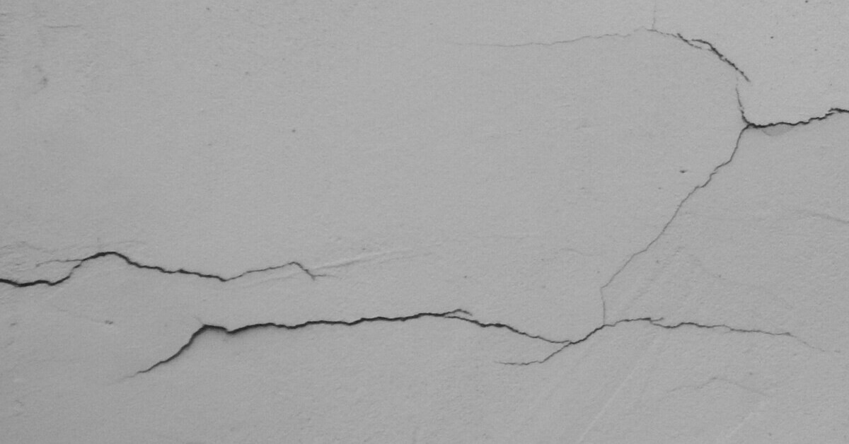 Risse im Putz – Nahaufnahme von feinen Rissen in der Putzoberfläche Risse im Putz in Nahaufnahme, Detailaufnahme von feinen Rissen in einer Putzoberfläche