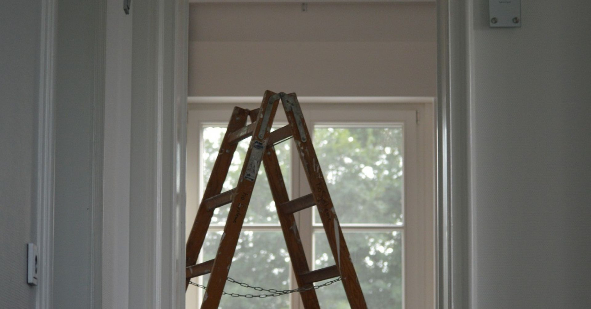 Holzleiter im Innenraum bei einem Hausbau-Projekt vor einem Fenster