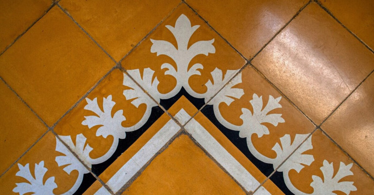 Angemalte Bodenfliesen mit dekorativem Muster in Gelb, Weiß und Schwarz