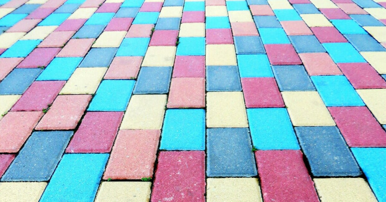 Angemalter Betonboden mit bunten Rechtecken in Blau, Gelb und Rot