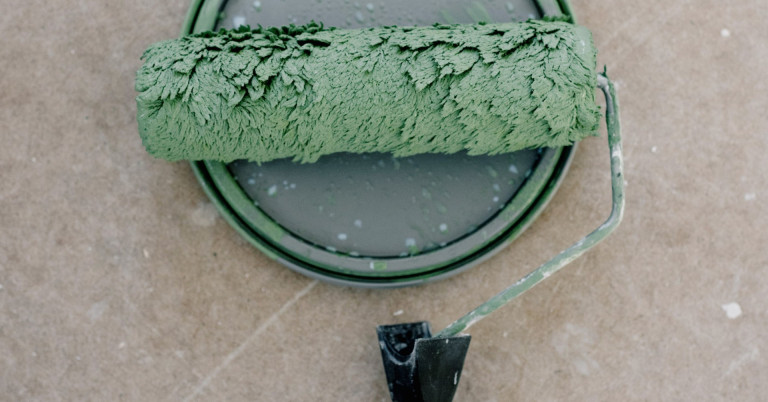 Farbrolle mit grüner Farbe – Malerwerkzeug für Renovierungsarbeiten Farbrolle mit grüner Farbe auf Farbdose, Malerwerkzeug für Renovierung oder Streichen