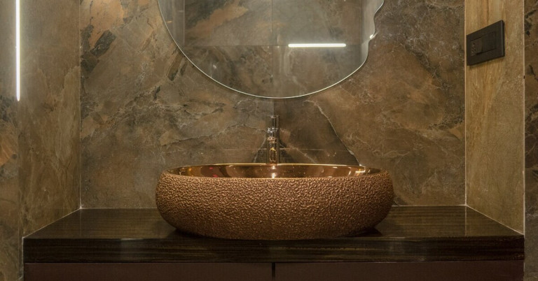 Modernes Bad mit Natursteinfliesen und elegantem Waschbecken