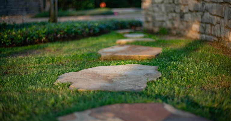 Trittsteine im Garten auf einer Rasenfläche als dekorativer Gartenweg