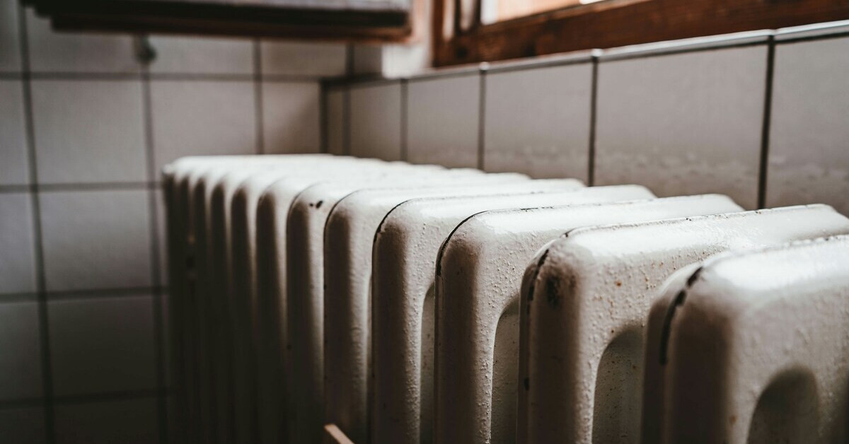 Alter Heizkörper aus Gusseisen in einem Raum mit Fliesenwand