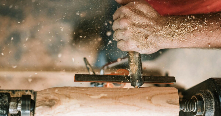 Handwerk: Nahaufnahme eines Handwerkers beim Arbeiten mit Holz und Werkzeug